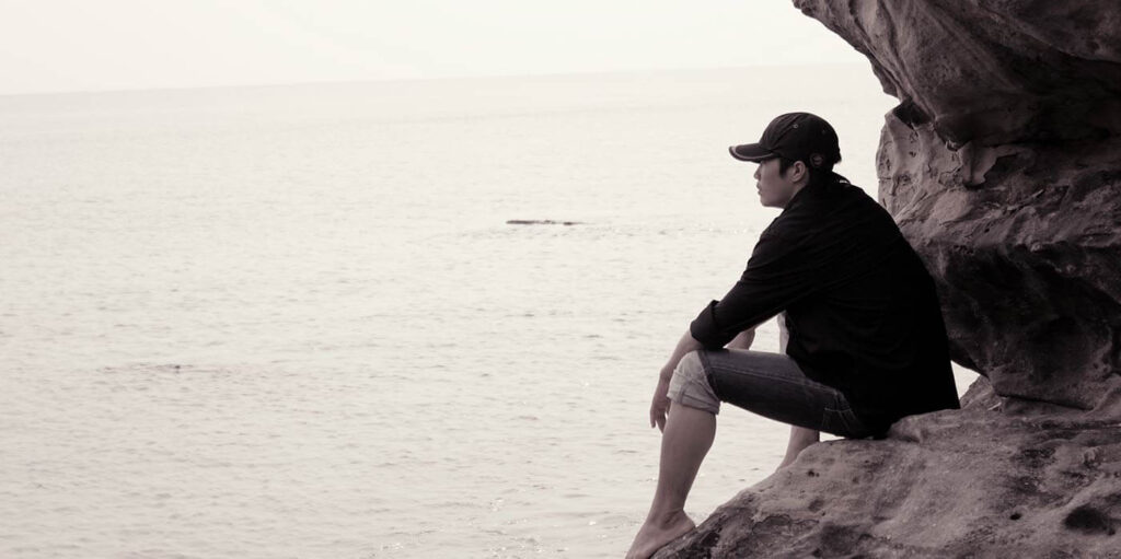 man-sitting-looking-out-to-sea